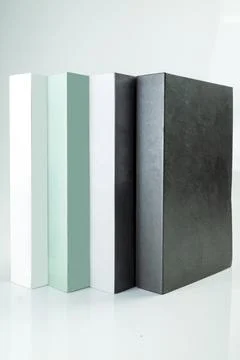 Four minimalist decorative books in white, mint green, grey, and black stan.. Stock Photos