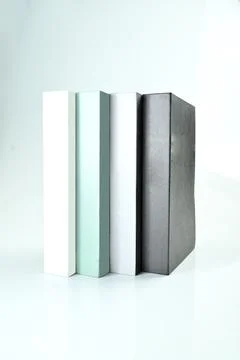 Four minimalist decorative books in white, mint green, grey, and black stan.. Stock Photos