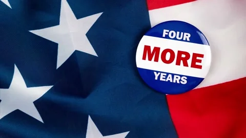 Four more years text quote on election button laying on the star spangled ban Stock Footage 170629575