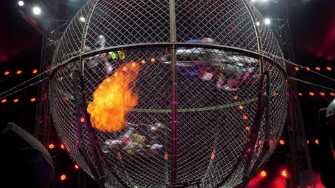 Four motorcyclists perform a dangerous stunt in a metal cage in the circus arena Stock Footage 308471194