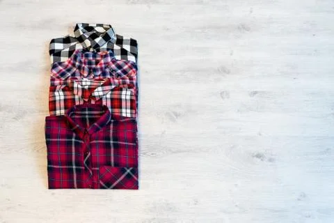 Four multi-colored checkered women's shirts lying neatly folded Stock Photos