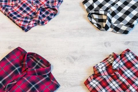 Four multi-colored checkered women's shirts lying neatly folded Stock Photos