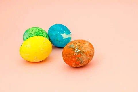 Four multi-colored Easter eggs on pink background top view, space for text. C Foto stock