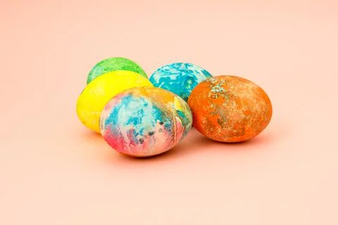Four multi-colored Easter eggs on pink background top view, space for text. C Foto stock
