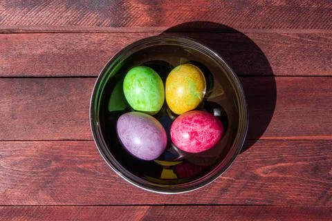 Four multicolored bright easter eggs in ceramic bowl Stock Photos