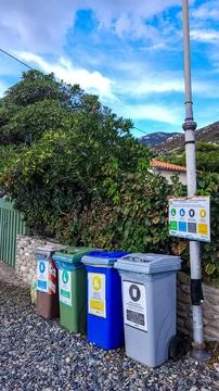 Four multicolored garbage sorting containers in the beach against the backdrop Stock Photos
