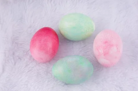 Four multicolored painted Easter eggs on white artificial rabbit fur. holiday Stock Photos