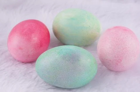 Four multicolored painted Easter eggs on white artificial rabbit fur. holiday Stock Photos
