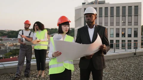 Four multiethnic engineers discussing construction process Stock Footage 246131041
