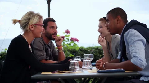 Four multiethnic friends are having fun chattering at italian restaurant Stock Footage 64518513