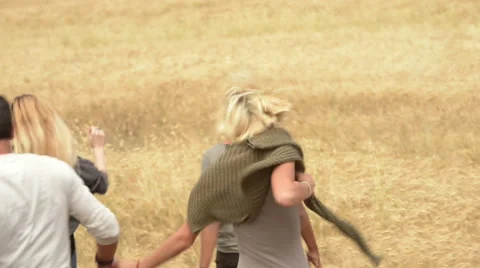 Four multiethnic friends having fun in summer day running in a cornfiled Video stock 64518443