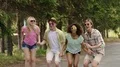 Four multiracial friends jumping together in park at open-air music festival HD Footage