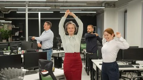 Four office workers warm up during a break. Employees do fitness exercises at Foto stock