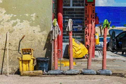 Four old plastic traffic post with wet rags over them and a couple of buckets Stock Photos