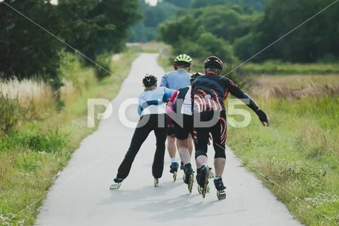 Four older people riding on roller skates in line Stock Photos