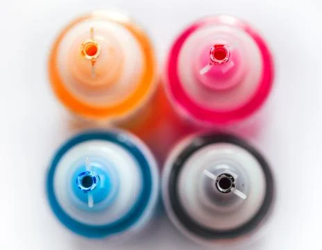 Four open printer bottles with CMYK colour ink. White background. Top view. Stock Photos