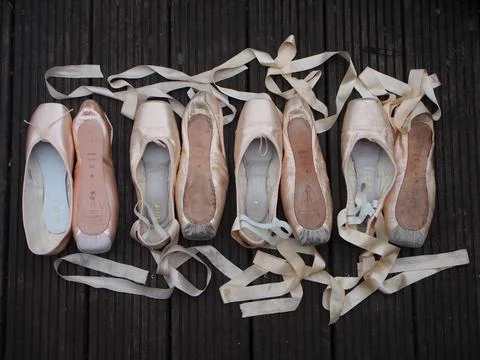 Four pairs of pointe shoes of the same kind laid out to show the progressio.. Stock Photos
