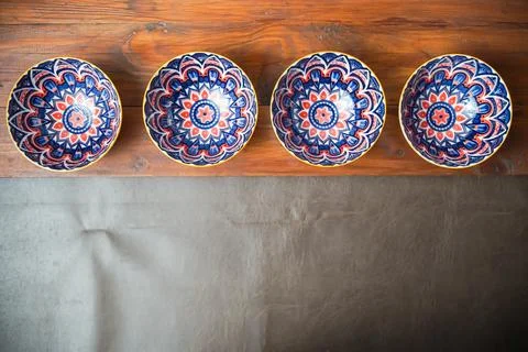 Four patterned ceramic bowls on rustic wood Stock Photos