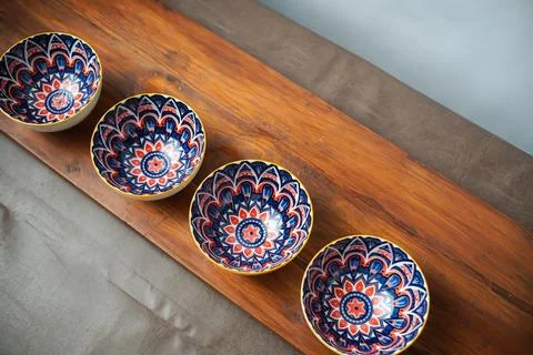 Four patterned ceramic bowls on rustic wood Stock Photos