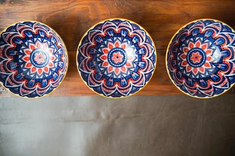 Four patterned ceramic bowls on rustic wood Stock Photos
