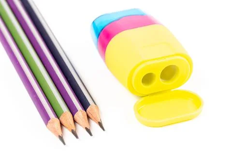 Four pencils and a multi-colored sharpener Stock Photos