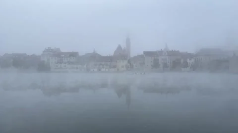 Four people are rowing oars on a kayak. Fog. Panorama of the Bavarian city. Stock Footage 223181279