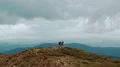 The four people with backpacks standing on a beautiful mountain 4k or 4k+ Resolution