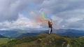 The four people with color smoke bombs standing on the mountain 4k or 4k+ Resolution