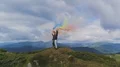 The four people with color smoke bombs standing on the mountain 4k or 4k+ Resolution