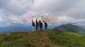 The four people with color smoke bombs standing on a mountain top 4k or 4k+ Resolution