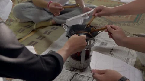 Four people dipping canting pen into a hot wax to draw traditional batik motif Stock Footage 259481986