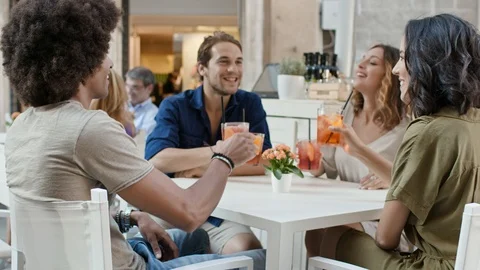 Four people or two couples happy toasting with cocktail at aperitif in city cafe Stock Footage 105831962