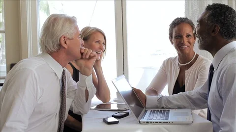 Four people relaxing while having their business meeting in the restaurant. Vidéo 88343187