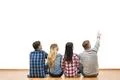 The four people sit on the floor and gesture on a white wall background Photo