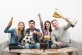 The four people on the sofa watch a football on the white background Photo
