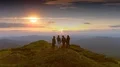 The four people standing on the mountain against a sunset 4k or 4k+ Resolution