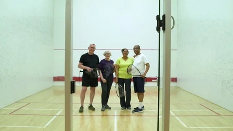 Four people standing on a squash court 動画素材 83413053