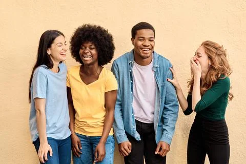 Four people standing while having fun together Stock Photos