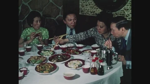 Four people, two couples, eating with chopsticks in Chinese restaurant in Stock Footage