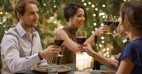 Four people, two couples happy talking and toasting with red wine during a Stock Footage 105828686