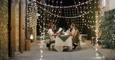 Four people, two couples happy talking and eating during a romantic gourmet Stockbeeldmateriaal 111481399