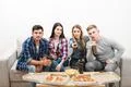 The four people watch tv with a pizza and a beer on the white background Photo