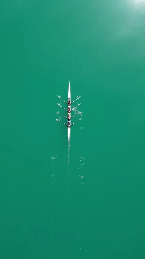 Four-person rowing team training on vibrant turquoise water watersport, top Stock Footage 341559947