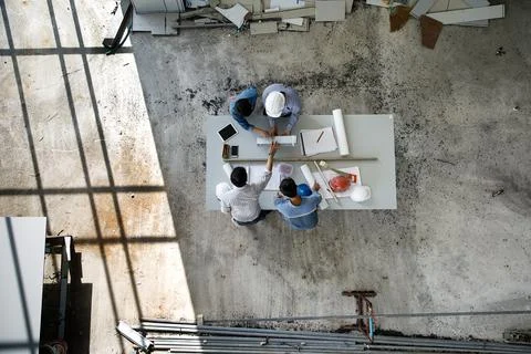 Four persons team of engineers talk together to review constuction material Stock Photos