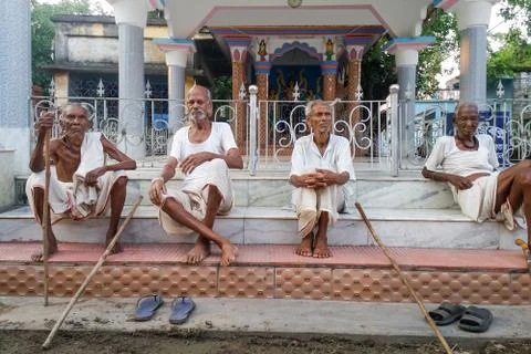 Four physically weak elderly Indians are sitting on the steps of a temple tal Stock Photos