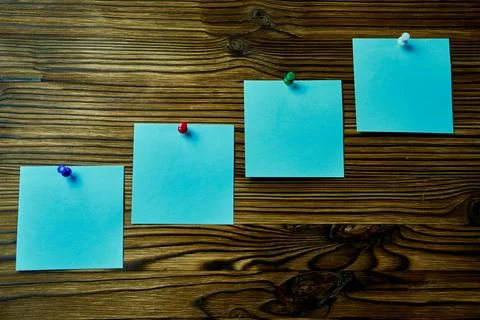 Four pieces of post-it notes on a wooden wall. Foto stock