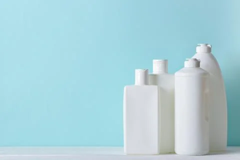 Four plastic white bottles on a light blue background. Foto stock