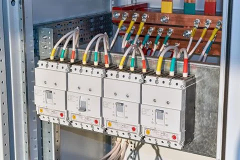 Four power circuit breakers are fixed in the electrical Cabinet in line. Stock Photos