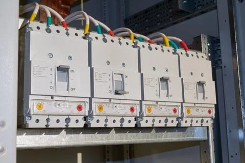 Four power circuit breakers are fixed in the electrical Cabinet in line. Stock Photos