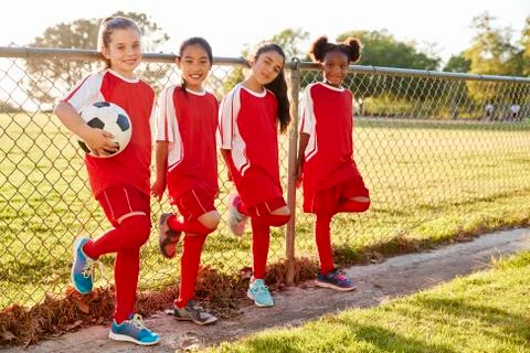 Four pre teen girls in a soccer team looking to camera Stock Photos